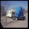 Assembled box on flat-bed trailer with the camping trailer parked in a slum in Las Cruces NM, 1986-7